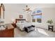 Spacious main bedroom featuring a ceiling fan and a large window with natural light and sitting bench at 9032 W Arizona Dr, Lakewood, CO 80232