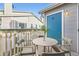 Cozy balcony featuring an outdoor dining set, string lights, and a blue accent door at 8358 Pebble Creek Way # 204, Highlands Ranch, CO 80126