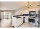 Open kitchen with stainless appliances, white cabinets, blue backsplash, and deck access at 8358 Pebble Creek Way # 204, Highlands Ranch, CO 80126