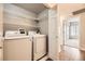 Convenient laundry room with washer, dryer, and wire shelving for organized storage at 8358 Pebble Creek Way # 204, Highlands Ranch, CO 80126