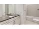 Bathroom with grey countertop, white cabinets and subway tiled tub at 3856 Treadway Pt, Castle Rock, CO 80108