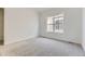 This bedroom features neutral carpeting, a window, and freshly painted white walls at 3856 Treadway Pt, Castle Rock, CO 80108
