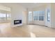 Cozy living room featuring a modern fireplace, hardwood floors and large windows with neighborhood views at 3856 Treadway Pt, Castle Rock, CO 80108