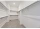 A walk-in closet with open white shelving and neutral carpet at 3856 Treadway Pt, Castle Rock, CO 80108