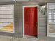 Condo entryway with red door and window looking into living area at 4450 S Pitkin St # 128, Aurora, CO 80015