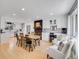 Open dining room with an adjacent kitchen features wood floors and modern white cabinetry at 6720 S Adams Way, Centennial, CO 80122