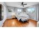 Bright main bedroom featuring hardwood floors, ceiling fan, ensuite bath, and natural light at 6720 S Adams Way, Centennial, CO 80122