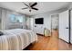 Bright main bedroom featuring hardwood floors, ceiling fan, ensuite bath, and natural light at 6720 S Adams Way, Centennial, CO 80122