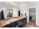 Bathroom with a large black vanity, double sinks, tile floor and a walk-in shower for a modern look at 18284 E 52Nd Pl, Denver, CO 80249