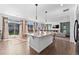 Open concept shows kitchen island, breakfast bar, living room with fireplace, and patio access at 18284 E 52Nd Pl, Denver, CO 80249