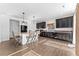 Modern kitchen features an island, breakfast bar, dark cabinetry, and stainless steel appliances at 18284 E 52Nd Pl, Denver, CO 80249