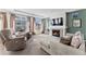 Bright living room featuring a fireplace, comfortable seating, and ample natural light through large windows at 18284 E 52Nd Pl, Denver, CO 80249