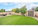 A well-maintained backyard featuring artificial grass, a patio set, and a storage shed at 1027 Auburn Dr, Erie, CO 80516