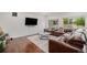 Bright living room with hardwood floors, large windows, and a comfortable leather sectional at 1027 Auburn Dr, Erie, CO 80516