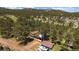 Stunning aerial view of mountain home nestled in a serene forest setting, perfect for nature lovers at 29827 Gigi Rd, Evergreen, CO 80439