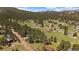 Mountain community with homes nestled among tall trees in a serene landscape at 29827 Gigi Rd, Evergreen, CO 80439
