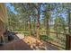 Large wooden deck with patio seating, grilling area, and scenic views of the property at 29827 Gigi Rd, Evergreen, CO 80439