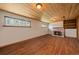 Cozy basement rec room with wood-paneled ceiling, stone fireplace, and hardwood floors at 29827 Gigi Rd, Evergreen, CO 80439