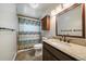 Bathroom with dark vanity, granite countertop, neutral walls, decorative shower curtain, and tiled floors at 29827 Gigi Rd, Evergreen, CO 80439