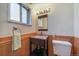 Charming bathroom featuring wood paneled walls, patterned wallpaper, and granite countertop sink at 29827 Gigi Rd, Evergreen, CO 80439