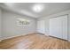 Bright bedroom with hardwood floors and white closet doors, enhanced by a large window and neutral walls at 29827 Gigi Rd, Evergreen, CO 80439