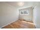 Empty bedroom features hardwood floors, fresh paint, and a large window for great tree-filled views at 29827 Gigi Rd, Evergreen, CO 80439