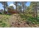 Charming home with a wooden deck nestled among tall trees and a well-maintained lawn at 29827 Gigi Rd, Evergreen, CO 80439