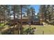 Exterior of home showcasing a large deck, patio and backyard with abundant pine trees at 29827 Gigi Rd, Evergreen, CO 80439