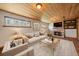 Cozy living room with stone fireplace, built-in bookshelves and wood plank ceiling at 29827 Gigi Rd, Evergreen, CO 80439