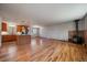 Spacious open-concept living area with hardwood floors, island, and a cozy wood-burning stove at 29827 Gigi Rd, Evergreen, CO 80439