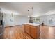 Open living room with hardwood floors, wood-burning fireplace, and a kitchen island for versatile living at 29827 Gigi Rd, Evergreen, CO 80439