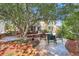 Spacious backyard with stone patio, mature trees, lush landscaping, and inviting seating area at 7762 S Eudora Ct, Centennial, CO 80122