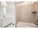 Bright bathroom featuring a tub with tile surround and a vanity with a modern sink at 631 Sunrise St, Erie, CO 80516