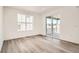 Bedroom featuring wood-look floors, large windows, and a sliding glass door leading to the backyard at 631 Sunrise St, Erie, CO 80516