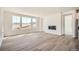 Modern living room with wood-look floors, a linear fireplace, and large windows with plenty of natural light at 631 Sunrise St, Erie, CO 80516