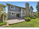 Well maintained backyard with a brick patio, grass, landscaping, and a gray house with many windows at 16257 E Belleview Pl, Centennial, CO 80015