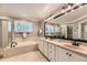 Bright bathroom with double vanity, soaking tub, glass shower and modern fixtures at 16257 E Belleview Pl, Centennial, CO 80015