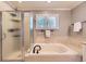 Modern bathroom with soaking tub, glass enclosed shower and neutral tile at 16257 E Belleview Pl, Centennial, CO 80015