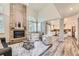 Open-concept living room with brick fireplace flowing into a bright kitchen space at 16257 E Belleview Pl, Centennial, CO 80015