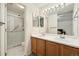 Bathroom featuring a double vanity, a large mirror, and a glass enclosed shower at 22070 Day Star Dr, Parker, CO 80138