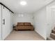 Finished basement rec room with a couch and barn door at 2929 N Josephine St, Denver, CO 80205