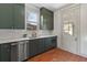 Kitchen boasts green cabinets, stainless steel appliances, and a window at 2929 N Josephine St, Denver, CO 80205