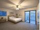 Bright bedroom with a ceiling fan, ensuite bath, and sliding glass doors to a private outdoor balcony at 10293 E Peakview Ave # F104, Englewood, CO 80111