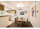 Cozy dining area featuring a four-seat dining table, a breakfast bar, and bright overhead lighting at 10293 E Peakview Ave # F104, Englewood, CO 80111