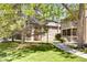 Condo building with green lawns, mature trees, and a welcoming walkway at 10293 E Peakview Ave # F104, Englewood, CO 80111