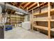 Unfinished basement area includes washer, dryer, utility sink, shelving and concrete flooring at 63 S Holman Way, Golden, CO 80401