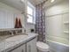 Bathroom with granite vanity, geometric shower curtain, and bathtub at 10306 Uvalda Ct, Commerce City, CO 80022