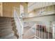 Open staircase with railing overlooking living room and fireplace at 19863 E Dartmouth Pl, Aurora, CO 80013