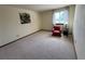 Cozy bedroom featuring carpeted flooring, a window, and a chair with side table at 2100 Robb St, Lakewood, CO 80215