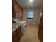 Functional laundry room with washer, dryer, sink, storage cabinets and window at 2100 Robb St, Lakewood, CO 80215